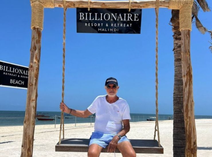 Flavio Briatore al Billionaire seduto su un'altalena in spiaggia
