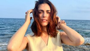 Miriam Leone con i capelli al vento e il mare di sfondo