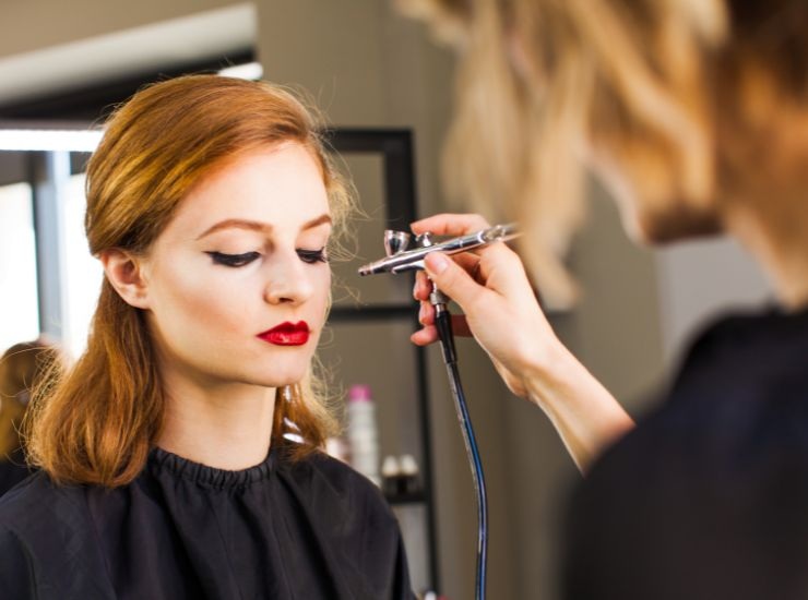 Ragazza che ritocca le sopracciglia con la tecnica airbrush