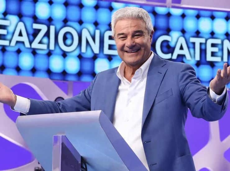 Pino Insegno con espressione sorridente a Reazione a Catena