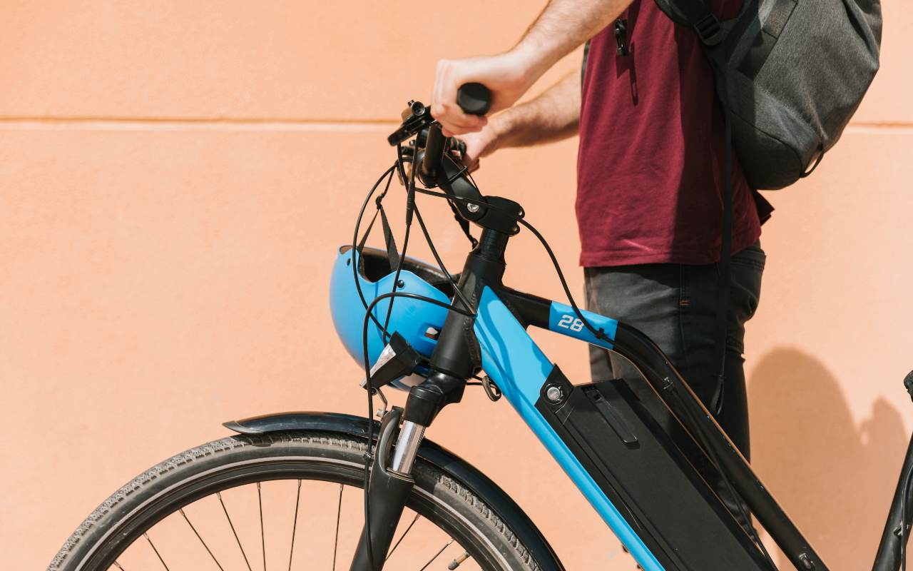 Un uomo in piedi accanto alla sua bicicletta elettrica